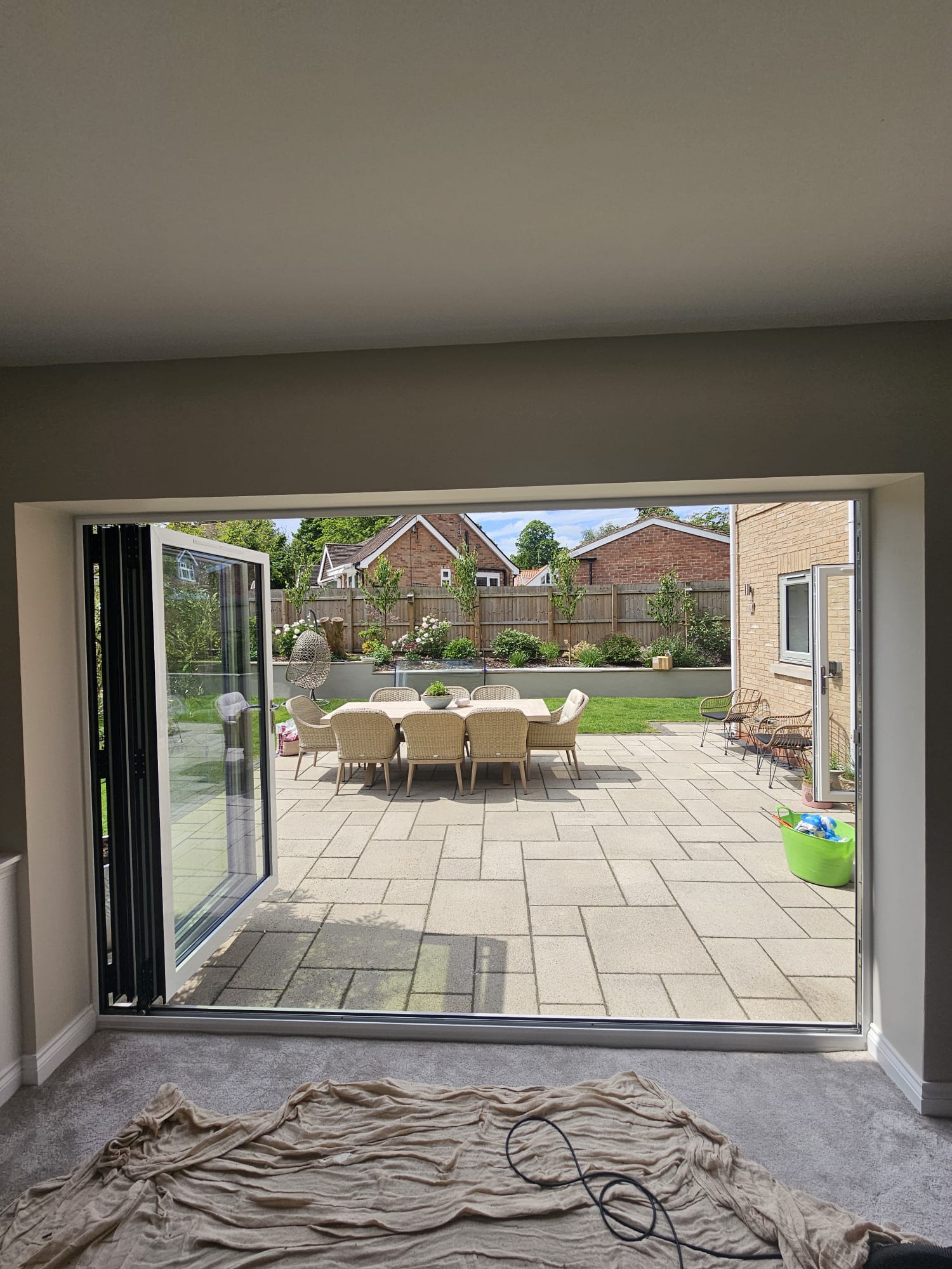 Agate grey aluminium bifold doors opening onto a garden, installed by WGS Glazing