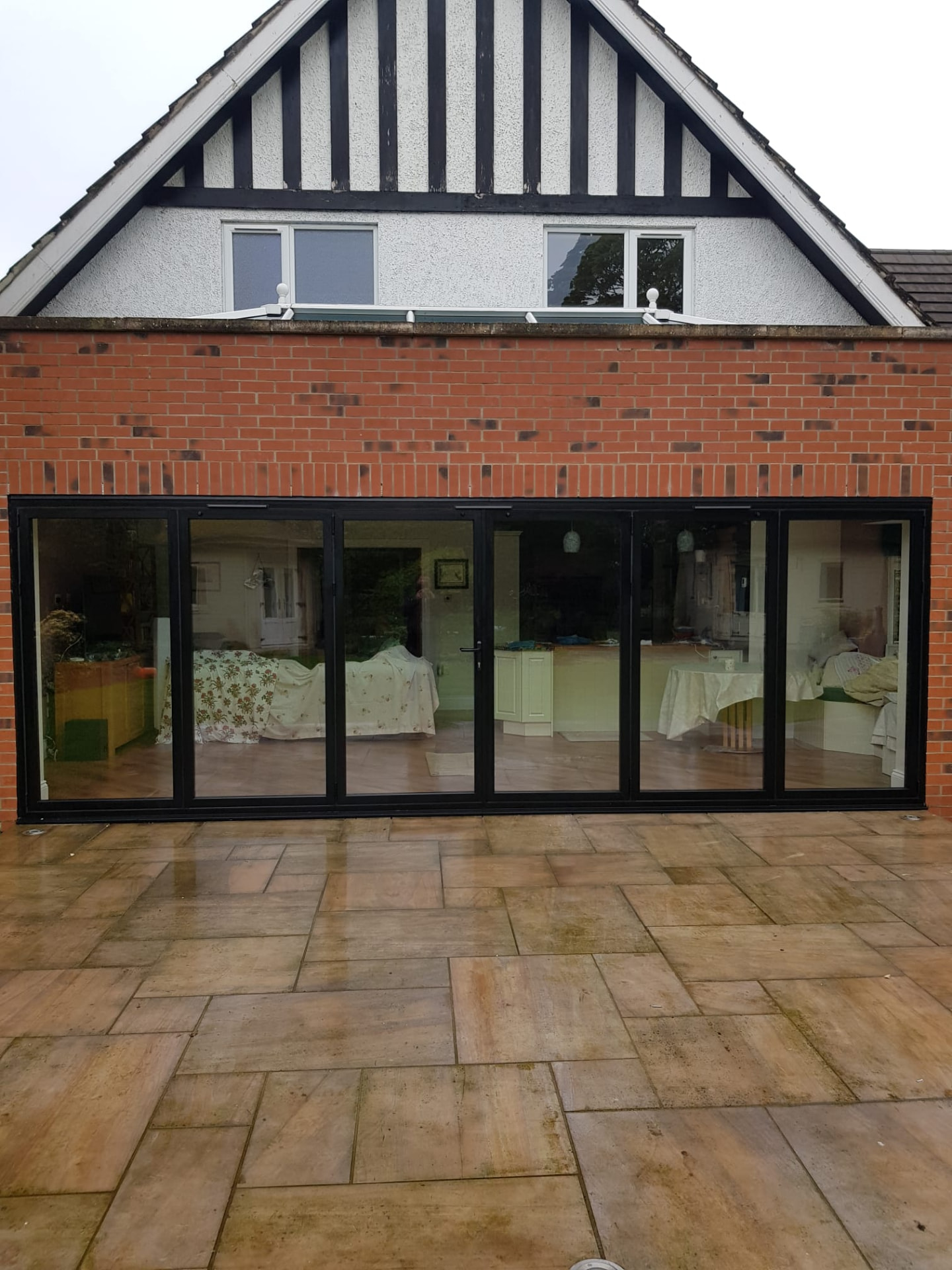 Anthracite aluminium bifold doors on a gable extension, installed by WGS Glazing