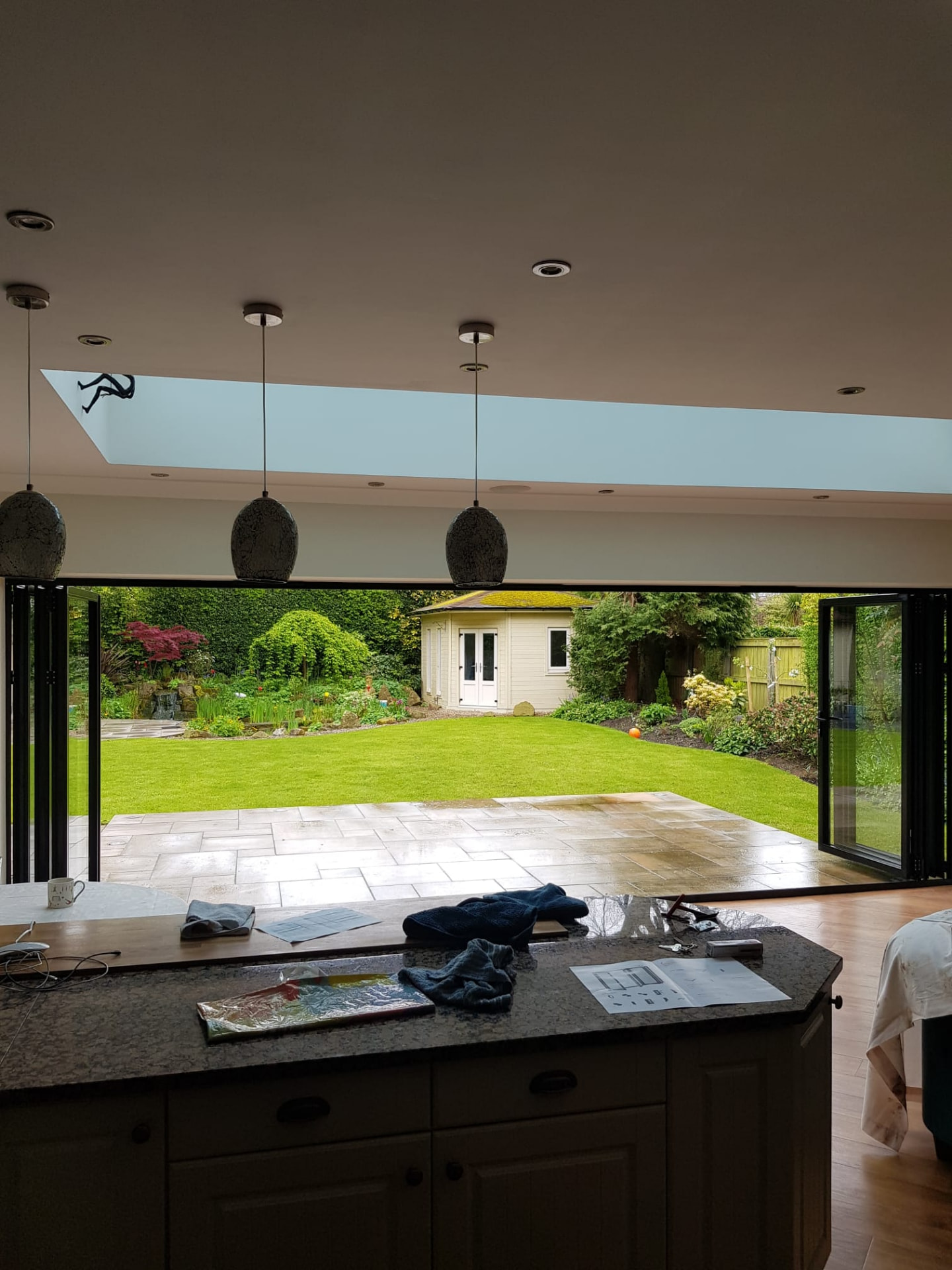 Open anthracite aluminium bifold doors inside a gable extension, installed by WGS Glazing