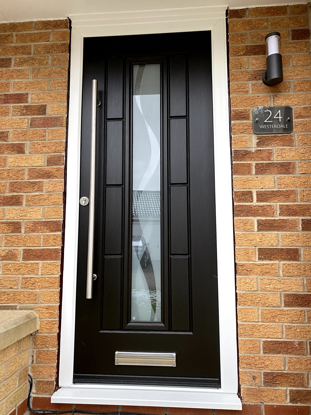 Black contemporary Rockdoor with long central glazed panel, supplied by WGS Glazing