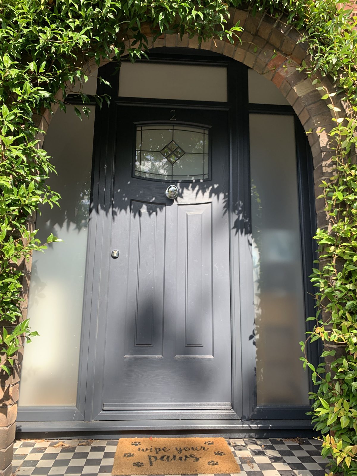 Black traditional Rockdoor with leaded glass and sidelights, supplied by WGS Glazing